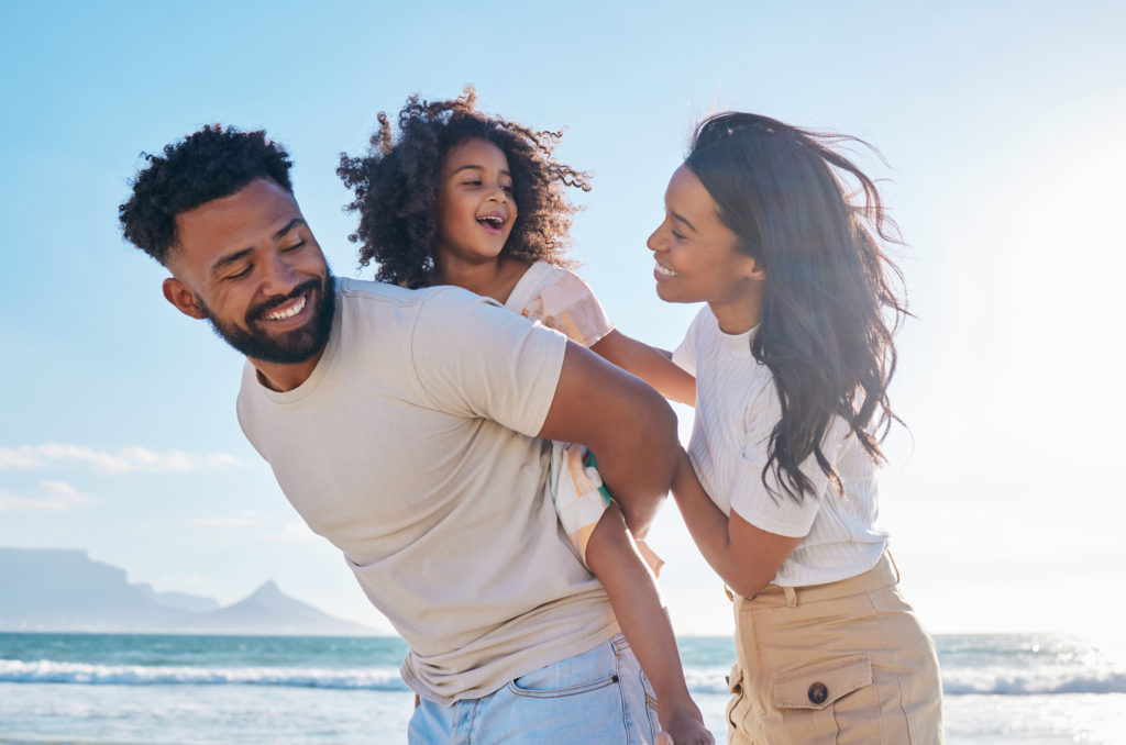 Happy family by the beach enjoying life instead of worrying about medical debt.